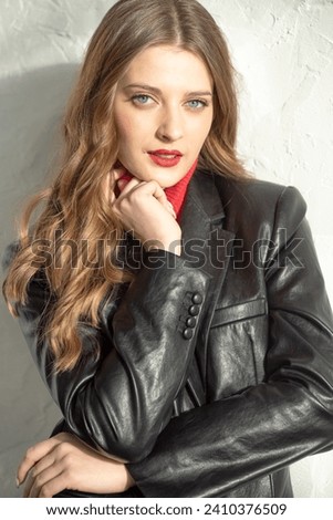 portrait of beautiful girl in black jacket, red pants and red lips.