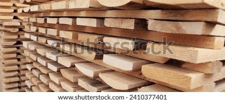 Large number of wooden pallets in production. Wooden pallets are in racks. Narrow banner.