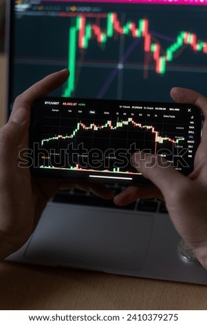 Smartphone with mobile application cryptocurrency wallet. A man analyzes the price chart for bitcoin in a mobile application. The concept of cryptocurrency trading