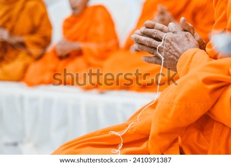 close up monk's hand holding holy thread, buddhist holy day, thai buddhist monk ordination ceremony wallpaper background concept Royalty-Free Stock Photo #2410391387
