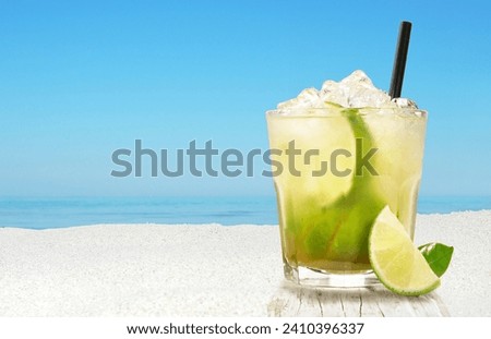 Caipirinha Cocktail on a Beach Background with Ocean View and blue Sky Royalty-Free Stock Photo #2410396337