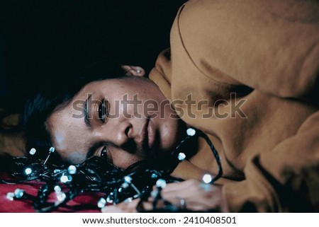 cool multiracial girl with a decorative light, playing with a decorative lights in her bed, photography with light.