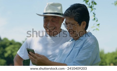 Happy and healthy couples Asian photo and VLOG selfie together for social media in park on leisure. Family and friendship lifestyle, Enjoyment of active seniors, and outdoor activity after retirement