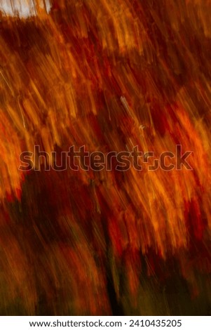 abstract blur background of fall or autumn colors in motion movement falling effect created by slow shutter speed and intentional camera movement fall leaves on trees in motion vertical fall backdrop 