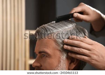 Hair styling. Professional hairdresser working with client in barbershop, closeup Royalty-Free Stock Photo #2410461113