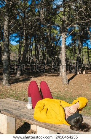 Exhausted young woman lies down on a wooden table after an exhausting day, looking for a well-deserved rest. Royalty-Free Stock Photo #2410464235
