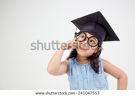 Happy Asian school kid graduate thinking with  graduation cap Royalty-Free Stock Photo #241047553