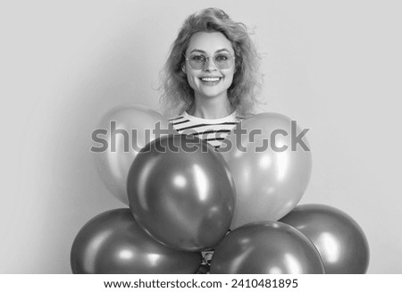 party woman with balloon in sunglasses. happy woman hold party balloons in studio.