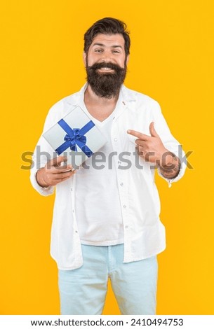 man offer sale gift on background, pointing finger. photo of man offer sale gift box.