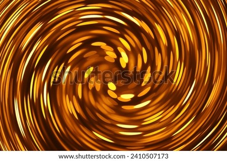 Gold caramel colored twirl spiral abstract. Twirled vortex as colorful abstract background made of golden, brown chrome and bronze glossy curve tubes on black. Magic fiery light spiral effect