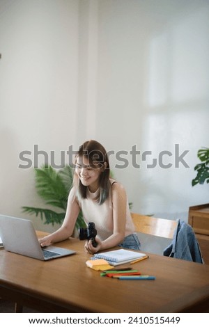 Creative designer woman using laptop to checking photo and working graphic design in home studio.
