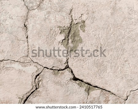 The wall of an old building with crumbling plaster and many winding, deep cracks. Copy space. Selective focus. Royalty-Free Stock Photo #2410517765