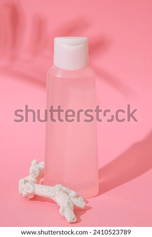 Natural healthy organic cosmetic product. Summertime concept pastel colored aesthetic photo with palm leaf shadow. Minimalistic sea coral. 