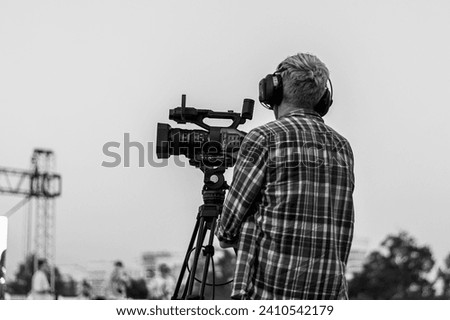 elderly man videographer films on camera in summer