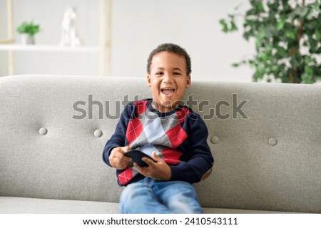 A boy sitting on sofa at home and watching TV