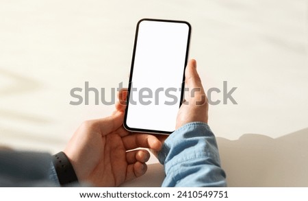 Millennial caucasian guy hand hold mobile phone with blank screen, work, study or online communication in cafe, cropped, pov. Website, blog and app recommendation, close up