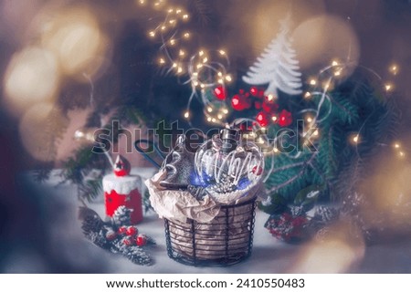 Wicker basket with Christmas toys under Christmas tree with lights. Christmas and New Year picture.