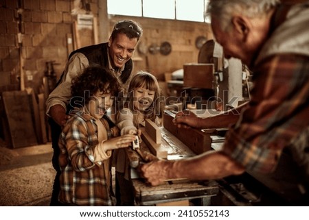 Multigenerational family having fun in woodshop Royalty-Free Stock Photo #2410552143