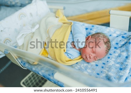 Newborn baby in blue romper. Photo of a newborn baby lying in a crib. The first photos of the baby.