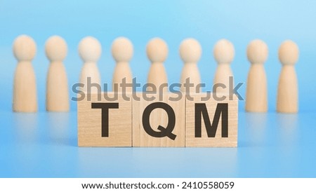 TQM letter on block on light blue background, business and finance concept Royalty-Free Stock Photo #2410558059