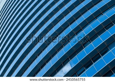 Diagonal intersection of blue glass skyscraper with reflections and white building lines Royalty-Free Stock Photo #2410565755