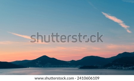 Sunset sky above Budva viewed from Sveti Stefan in Montenegro. Royalty-Free Stock Photo #2410606109