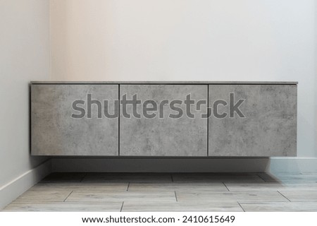 Modern furniture. Wall-mounted wooden cabinet with drawers in a modern apartment Royalty-Free Stock Photo #2410615649