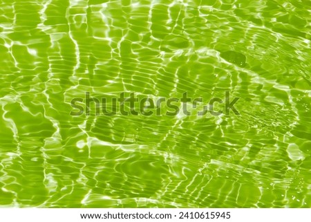  Green water waves on the surface ripple blurred. Defocus blurred transparent blue colored clear calm water surface texture with splash and bubbles. Water waves with shining pattern texture background