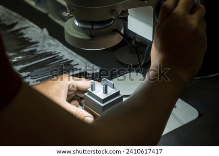 The graphite electrode quality control after milling process. The Graphite electrode quality check by microscope. Royalty-Free Stock Photo #2410617417