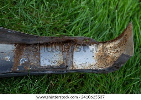 rusty metal bumper on a background of green grass