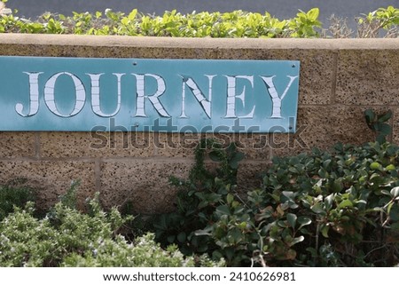 Sidewalk sign of Journey on a light blue background 