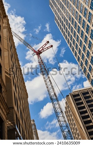Red Construction Crane and Diverse Architecture Against Blue Sky