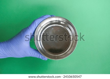 medical personnel wearing blue gloves holding sterile comms or instrument comms, usually use sterile fluids Royalty-Free Stock Photo #2410650547