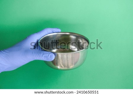 medical personnel wearing blue gloves holding sterile comms or instrument comms, usually use sterile fluids Royalty-Free Stock Photo #2410650551