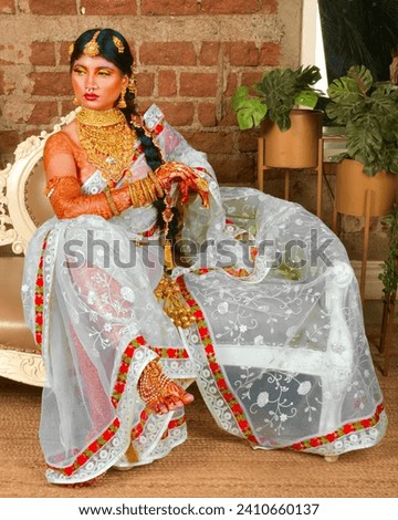 Indian Bridal portrait of beautiful bride wearing white saree and ethnic jewellery as tradition of Indian culture during wedding 