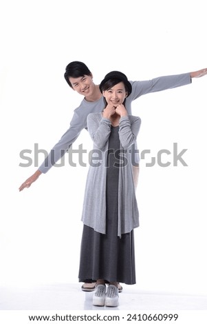 Full body Smiling young couple standing together, posing in studio Royalty-Free Stock Photo #2410660999
