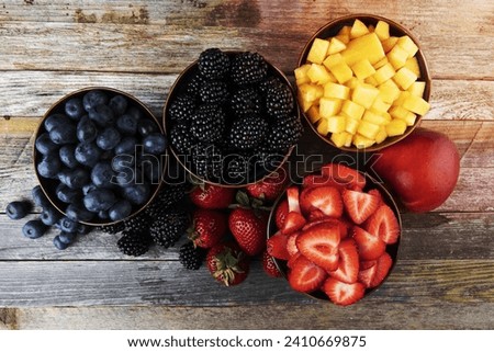 Flat lay of fres strawberries, blueberries, blackberreis and nectaries in bowls. Royalty-Free Stock Photo #2410669875