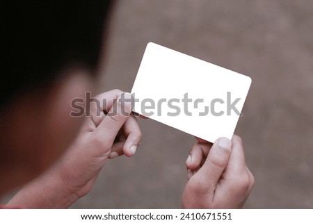 Hand holding a blank white card, great for mock up banking cards, identity cards, credit cards, and others