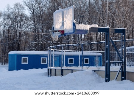 Part of a basketball court with a backboard in a winter outdoor setting