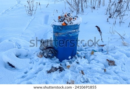 Garbage dump under snow. Dirt and stench. Mud in the streets. Environmental issues. Poor areas of the city. City infrastructure and its problems. Bad quality of life. Royalty-Free Stock Photo #2410691855