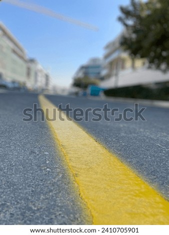 Road markings to regulate the traffic of cars, the picture shows a yellow solid line on the street asphalt