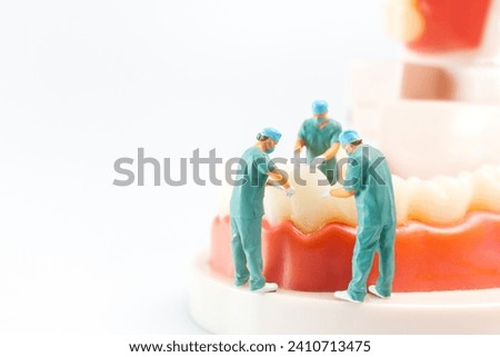 Miniature people , Dentist repairing human teeth with gums and enamel , Health and medical concept Royalty-Free Stock Photo #2410713475