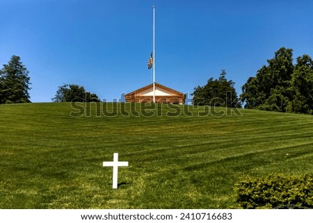 Panoramic view of a white marble cross in front of the pantheon and house at Arlington National Cemetery, a military cemetery in Washington DC, (USA). Royalty-Free Stock Photo #2410716683