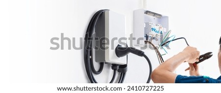 Certified male Electrician Installing Home EV Charger Royalty-Free Stock Photo #2410727225