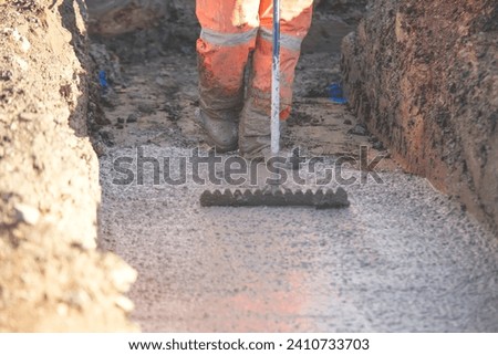 Concrete cast-in-place work. Builder leveling wet concrete. Concrete works on building construction site Royalty-Free Stock Photo #2410733703