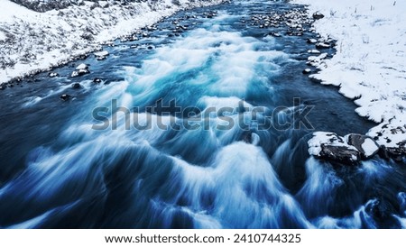 Amazing view on the river with strong flowing stream water in it, cold weather, beautiful wintertime landscape of Iceland