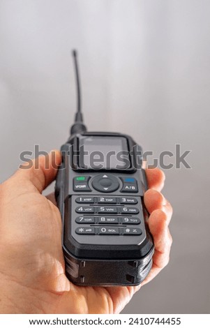 amateur radio walkie talkie portable triband held in the hand of a white man Royalty-Free Stock Photo #2410744455