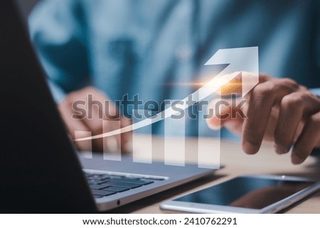 Businessman use laptop with virtual screen of economic growth graph for business strategy, data analysis technology and financial growth concept.