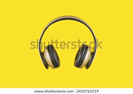 Studio photo with copy space of a wireless headphone in a yellow background