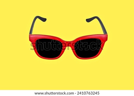 Studio photo with copy space of a red sunglasses in a yellow background